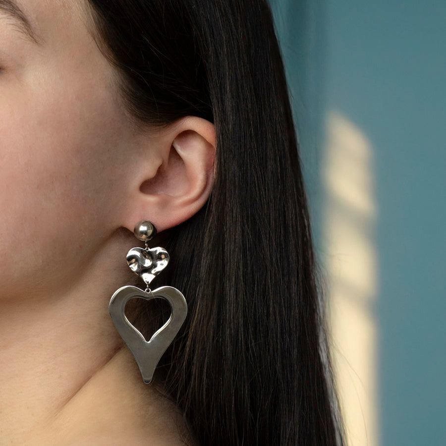 Stainless steel oorbellen in een hart vorm en zilverkleurig gedragen door model