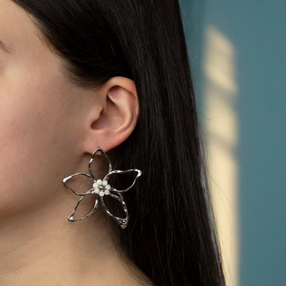 Stainless steel oorbellen in bloem vorm gedragen door model