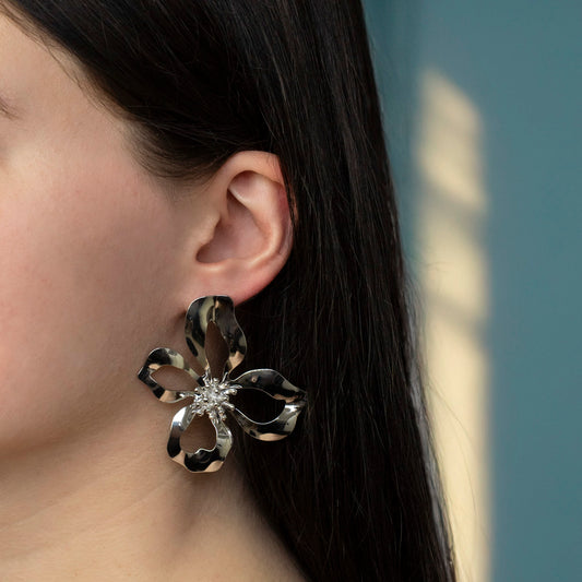 Grote bloem oorbellen gedragen door model